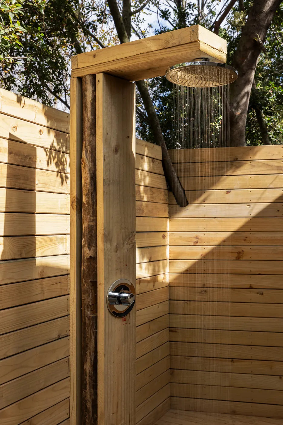 Open-air shower among the trees at The Well at Nine Yards