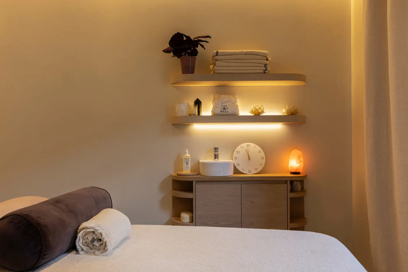 Massage therapy room with a linen-dressed table at The Well