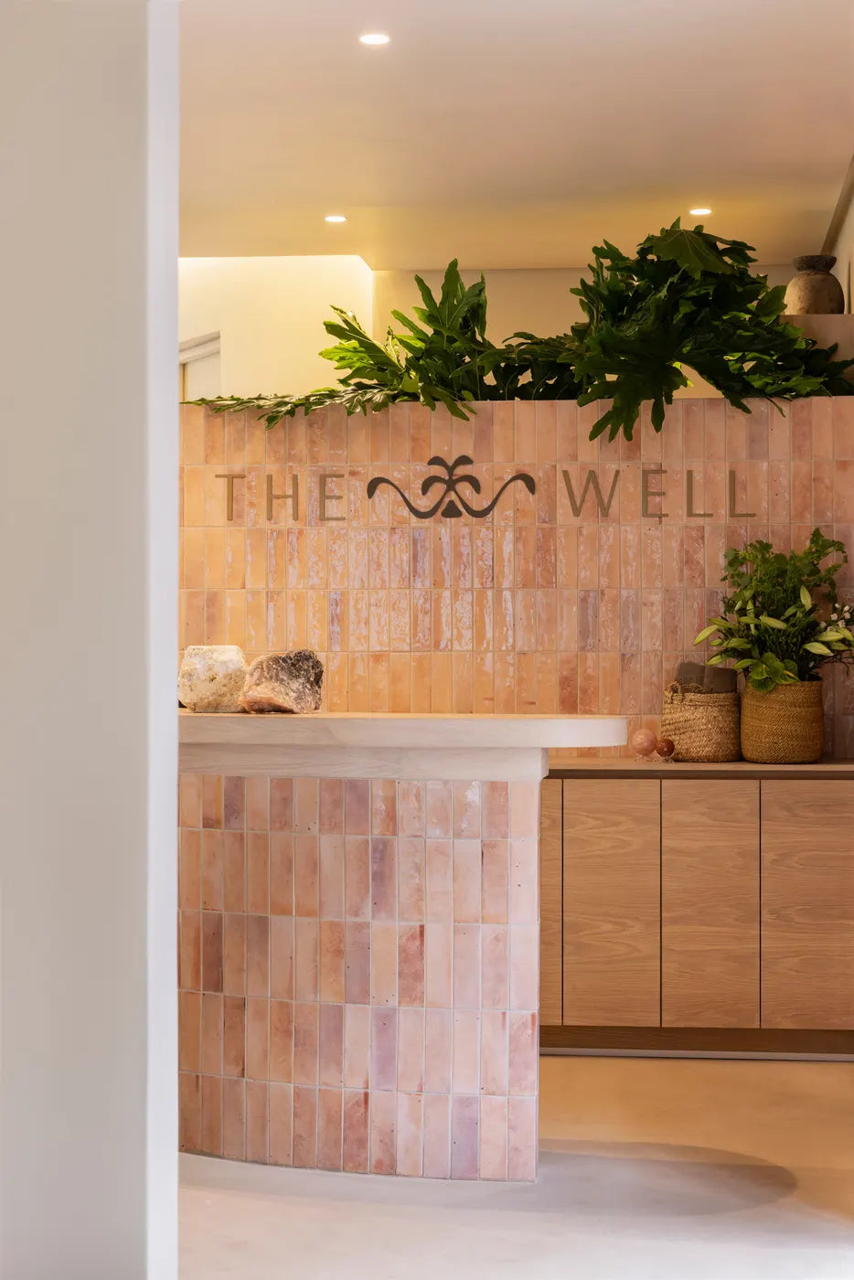The Well reception desk with its signature tiled wall and logo