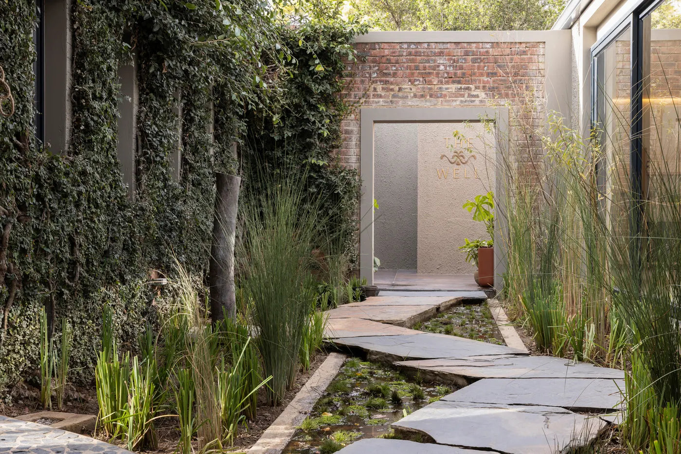 Landscaped garden path with reeds at The Well wellness sanctuary